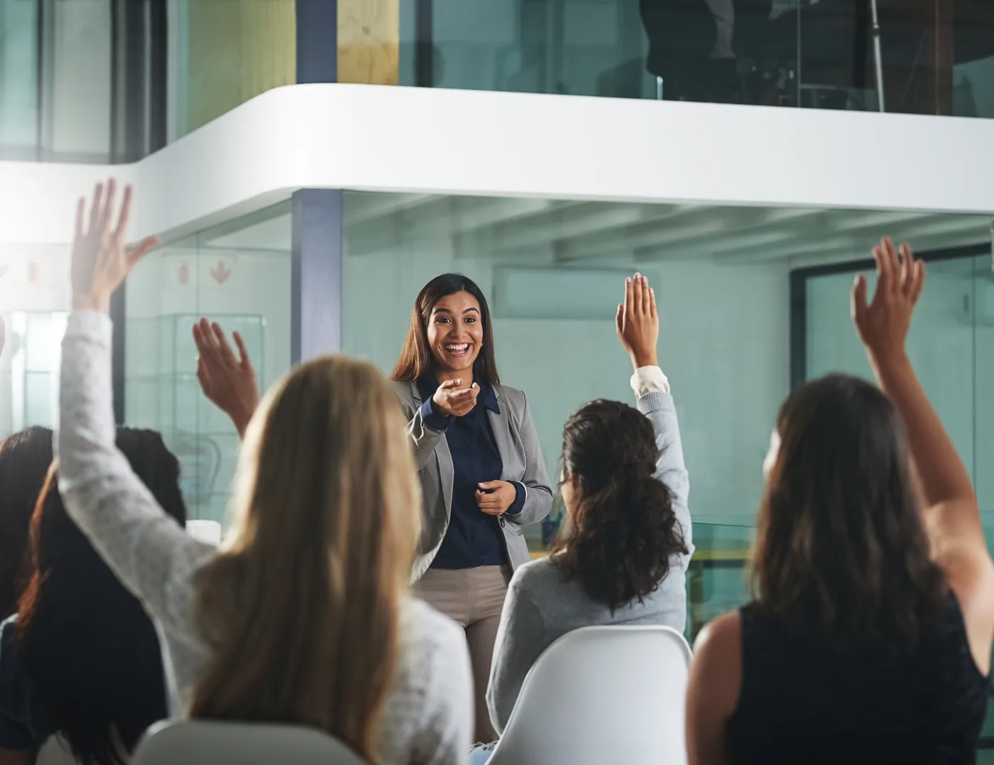 Educator leading a session with an engaged audience raising hands