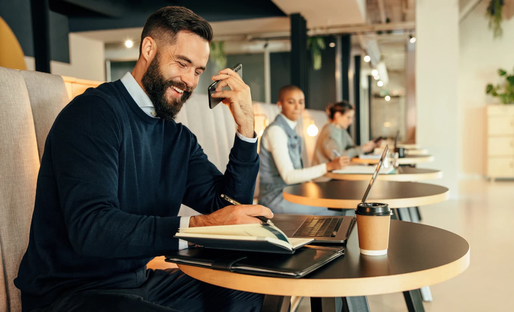 A professional working on a laptop in a bright, modern coworking space