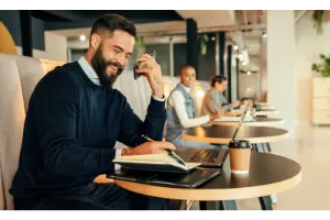 Happy businessman taking a phone call in a co-working space